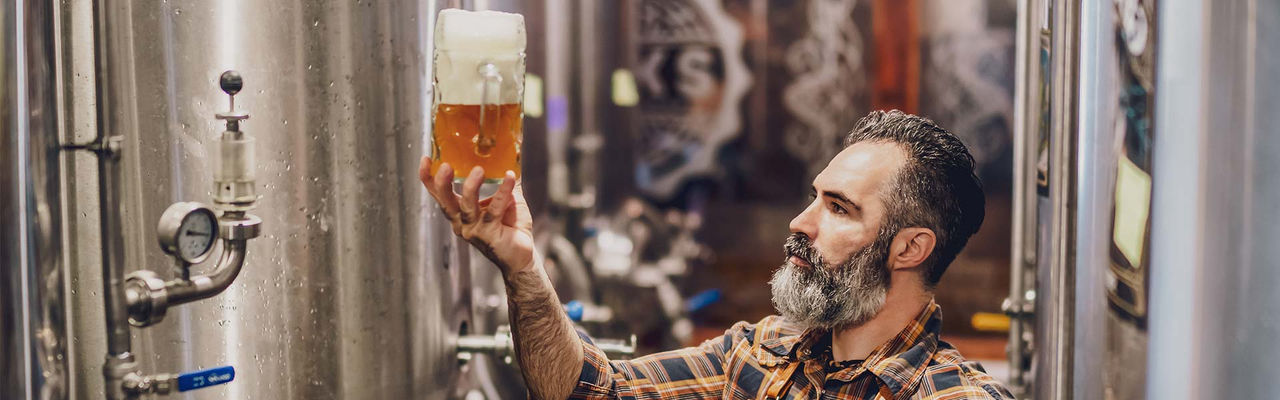 Braumeister hält ein Glas Bier in der Hand