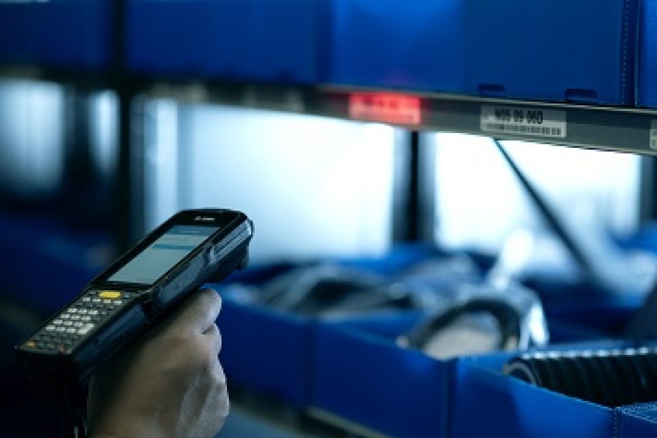 ERIKS | Karriere | Digitalisierung Ein Mitarbeiter scannt blaue Kisten ein